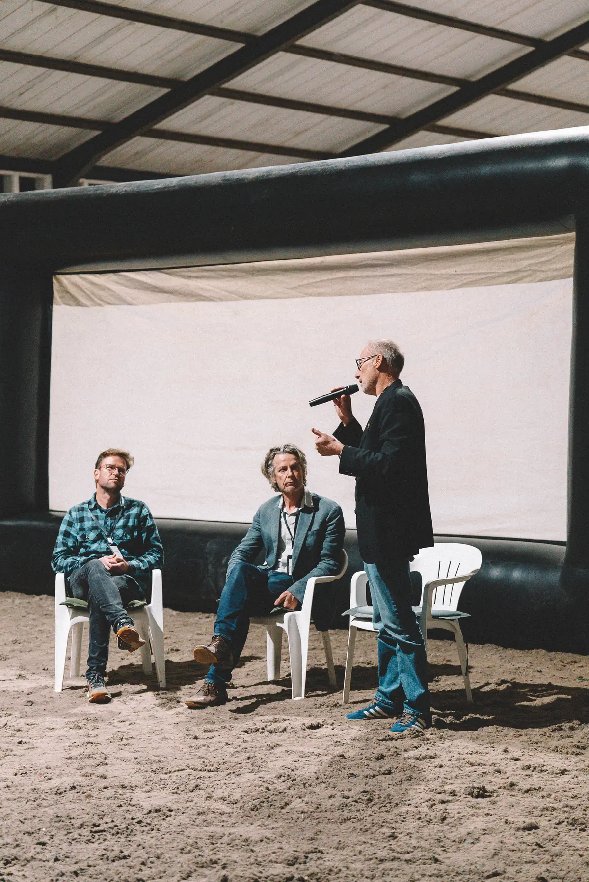 The question-and-answer panel after the screening, three speakers in front of the screen